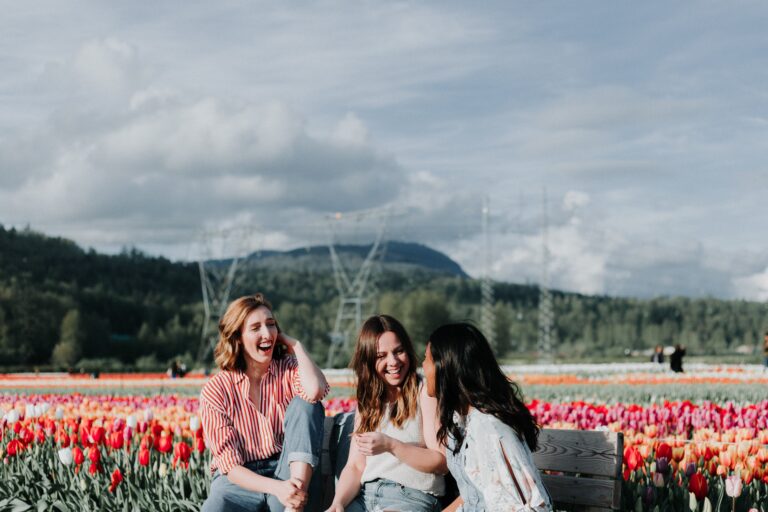 three female friends laughing by tulip field