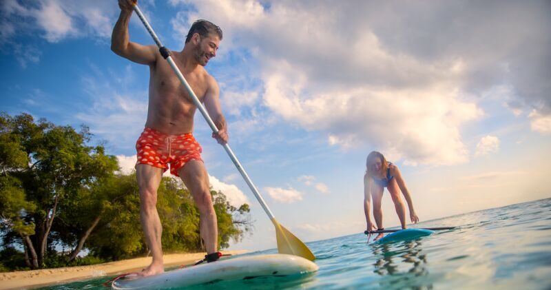 barbados couple paddleboarding