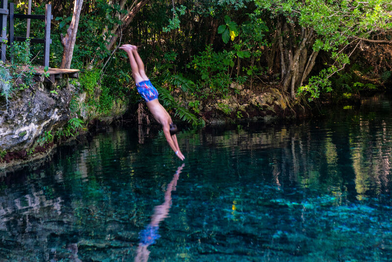 Boy jumping into a lagoon dominican republic p&o cruises caribbean