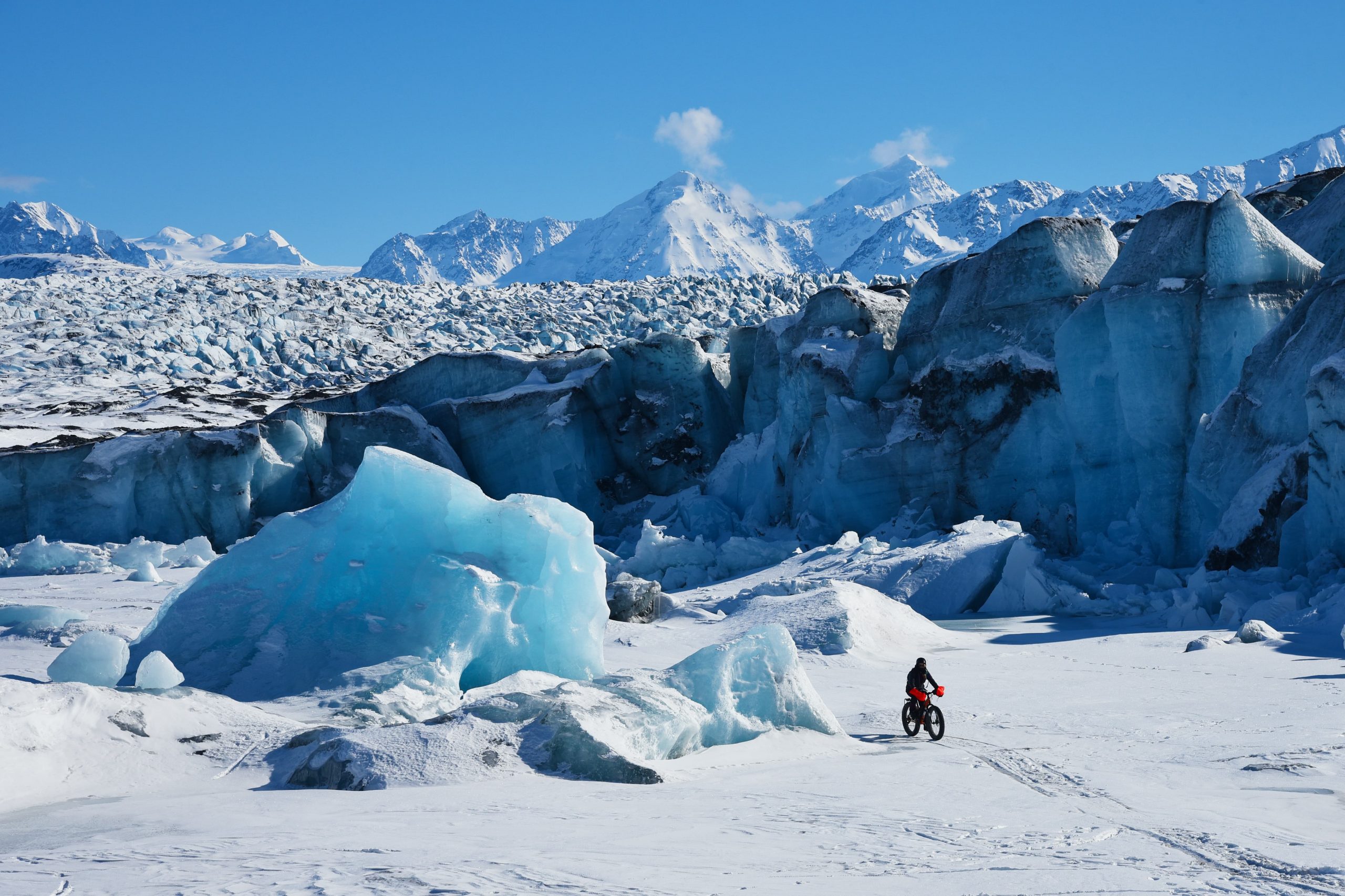 Man riding a big on a the ice at Kink Glacier in Alaska