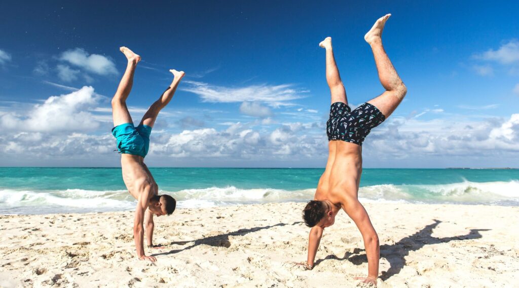 men-headstands-on-the-sand-cuba cruises for fun